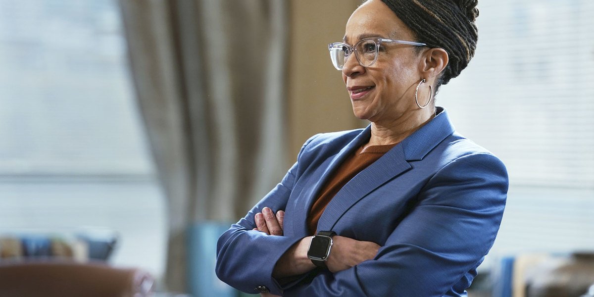 S. Epatha Merkerson standing with her arms crossed wearing a blue blazer in an office