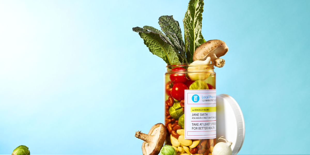 Assortment of vegetables in a prescription container in front of a light blue background