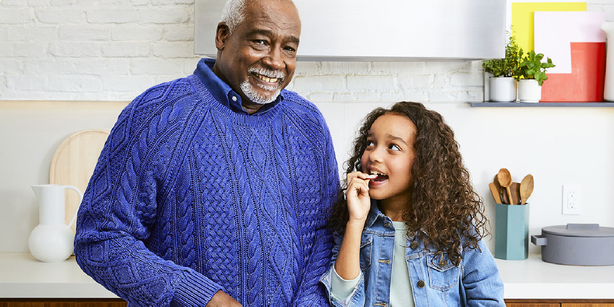 grandfather and granddaughter together cooking in a kitchen