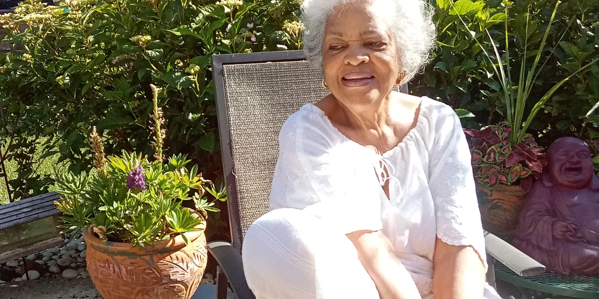 Member Myrna Harris sitting in her garden patio.